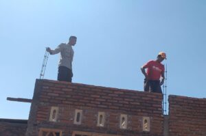 Gotong Royong Bersama Bhabinkamtibmas, Warga Desa Rumak Bangun Rumah Layak Huni